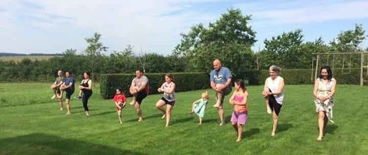 Fleming Athletics outdoor group training session — barefoot athletes in mid-movement on grass