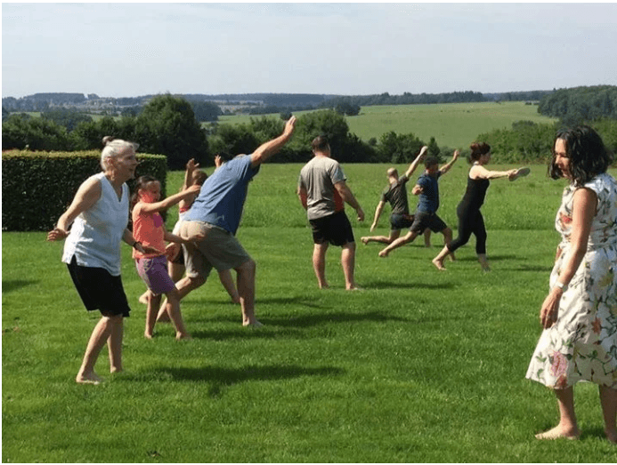 Fleming Athletics group training — athletes in dynamic reaching movements outdoors